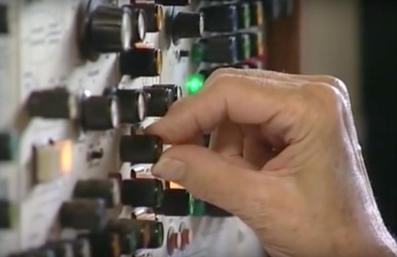 Un artiste français travaillant dans son studio, entouré d'instruments et de matériel électronique pour créer de l'art contemporain musique